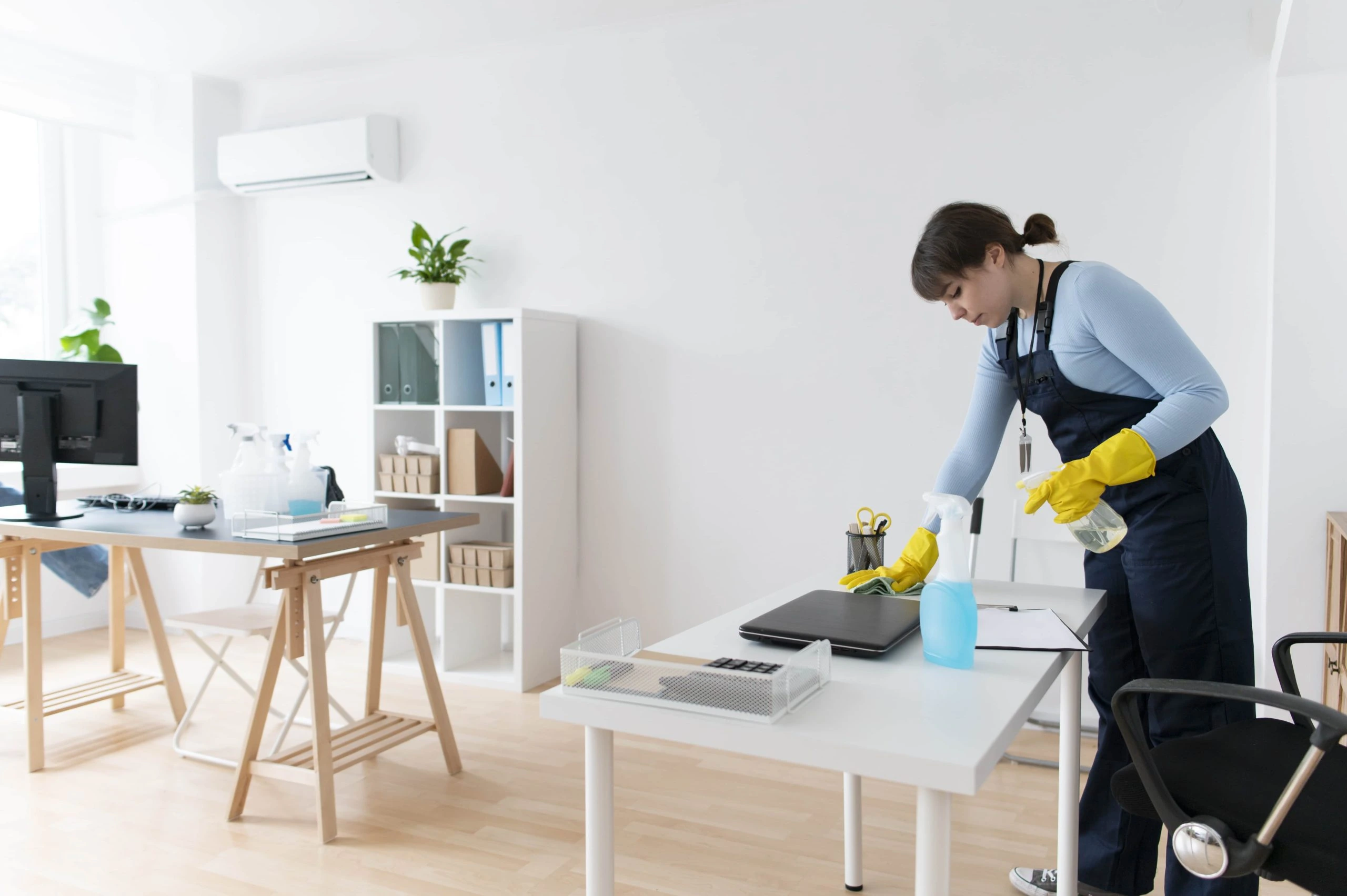 hiring-a-cleaning-services A professional cleaner from VV Maids Cleaning Services in NY organizes and sanitizes a modern office space with cleaning