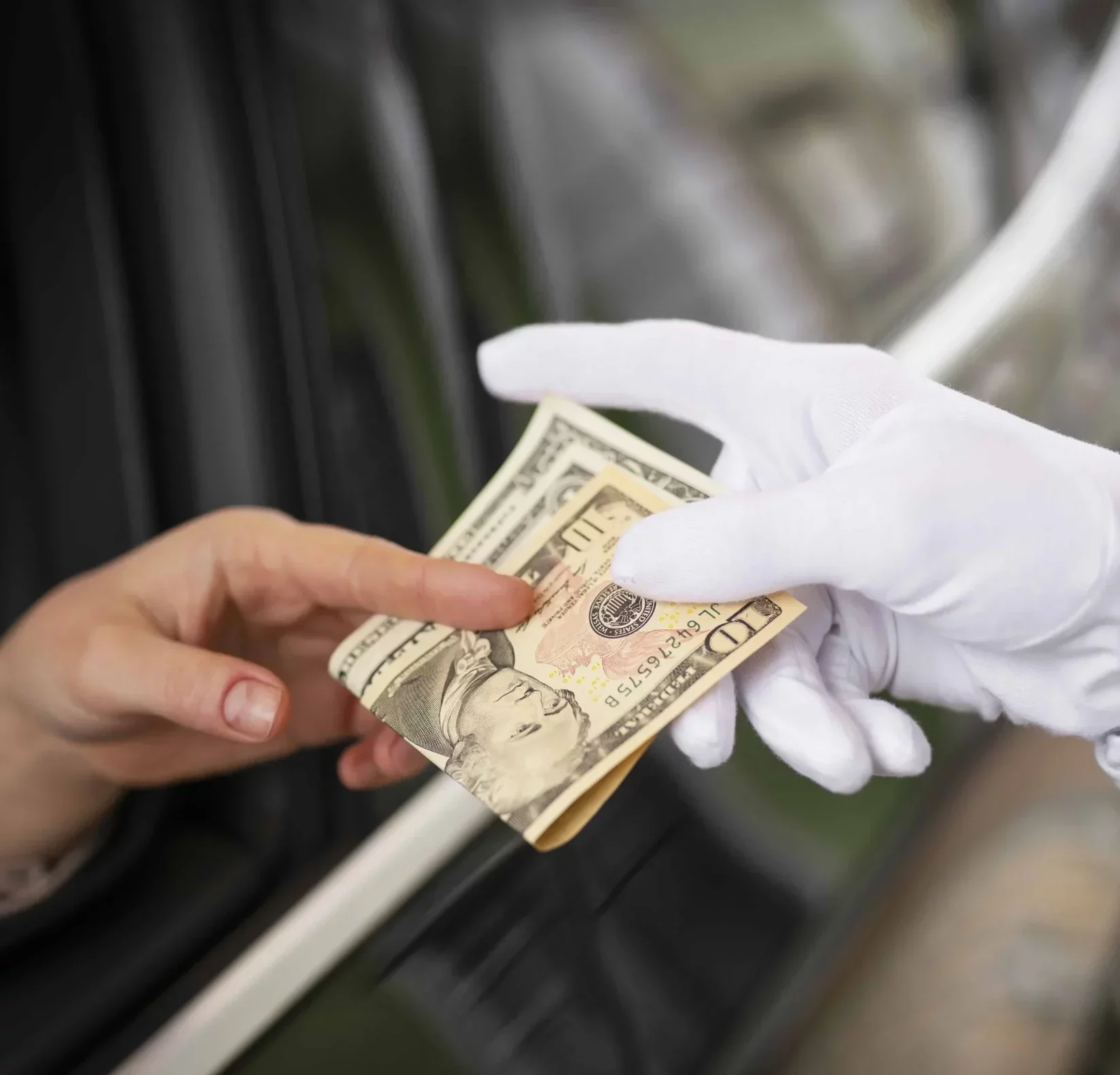 person's hand in white gloves getting some dollar bins from another person