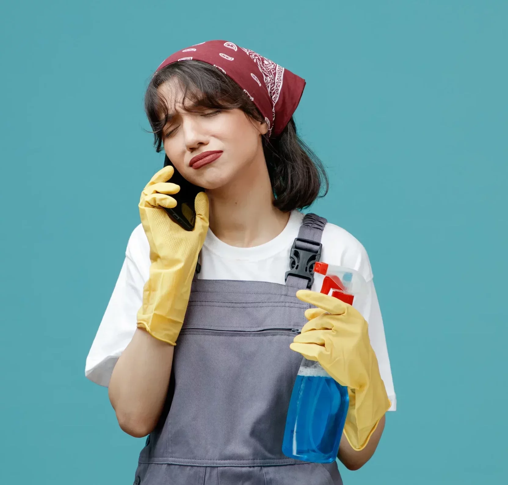 young female cleaner looking sad while talking to the phone