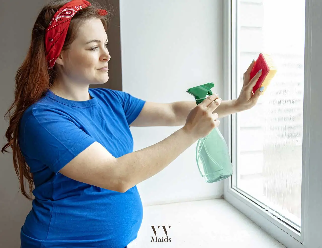 pregnant woman is cleaning the home