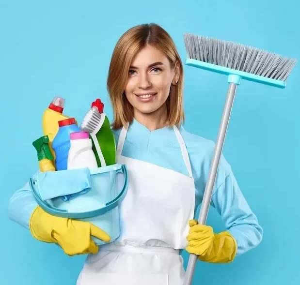 female professional cleaner smiling while holding cleaning products