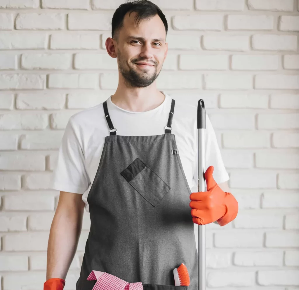 young male professional cleaner smiling while showing a thumbs up
