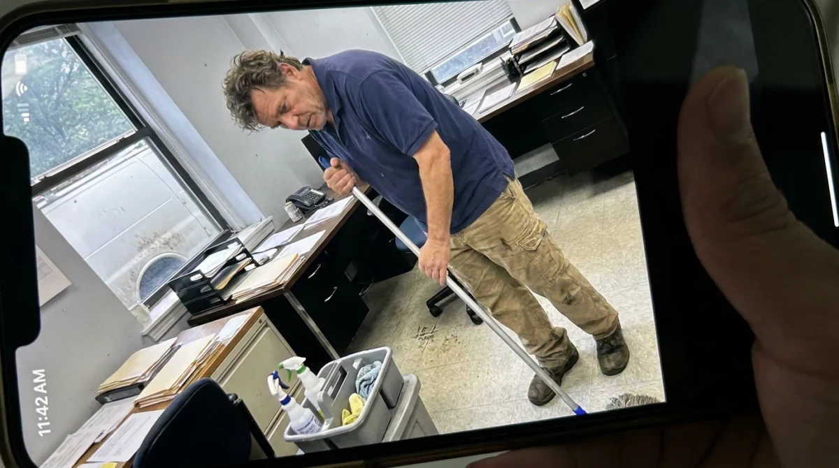 Cleaner mopping floor in office space